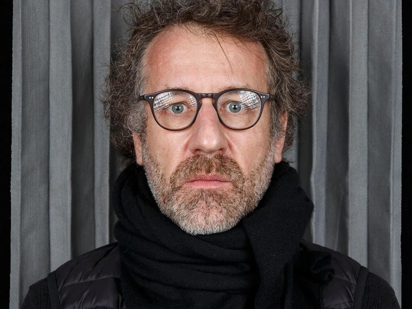 Portrait of photographer Olivier Culmann with grey background