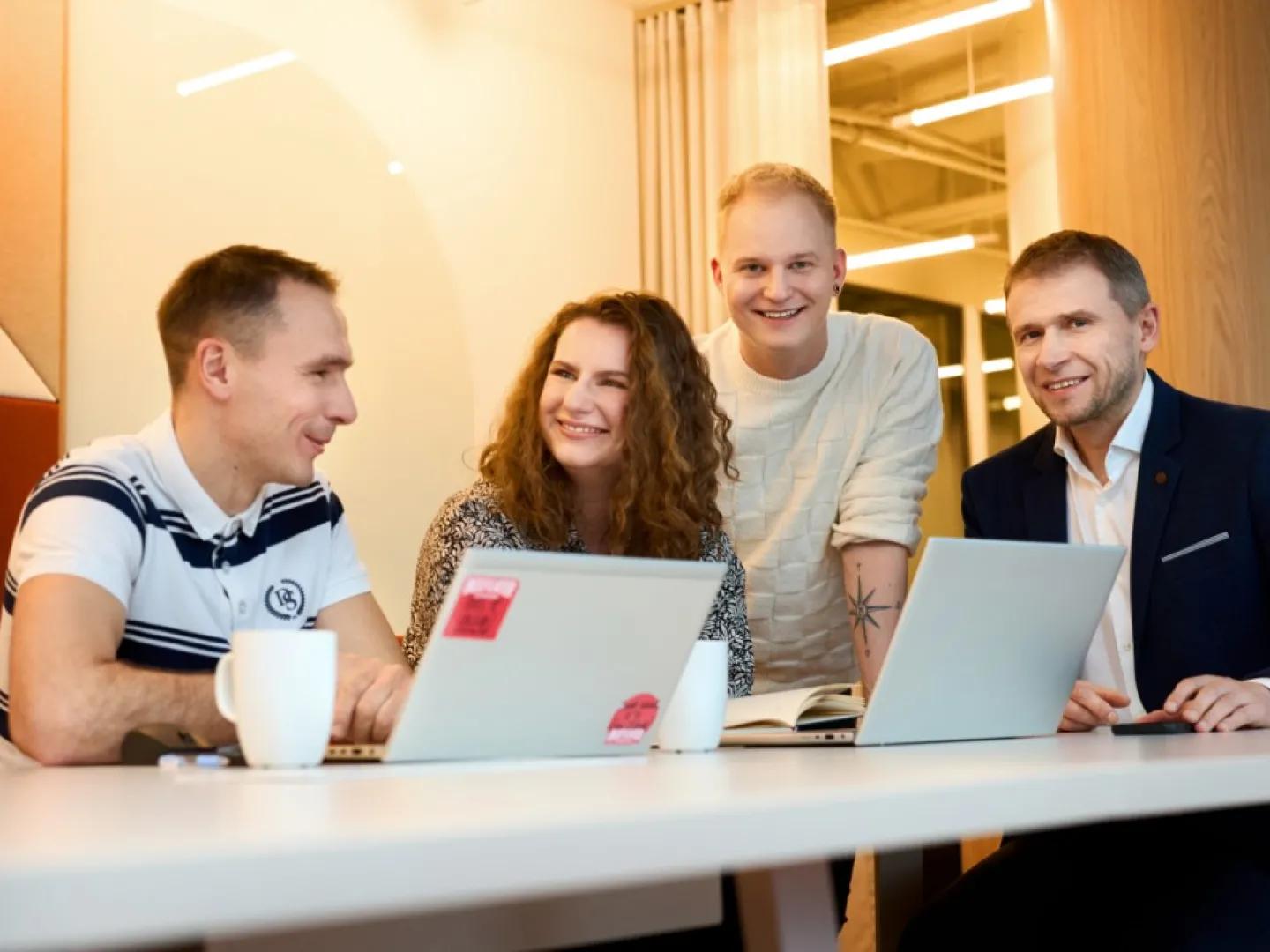 two man and two women with two laptops