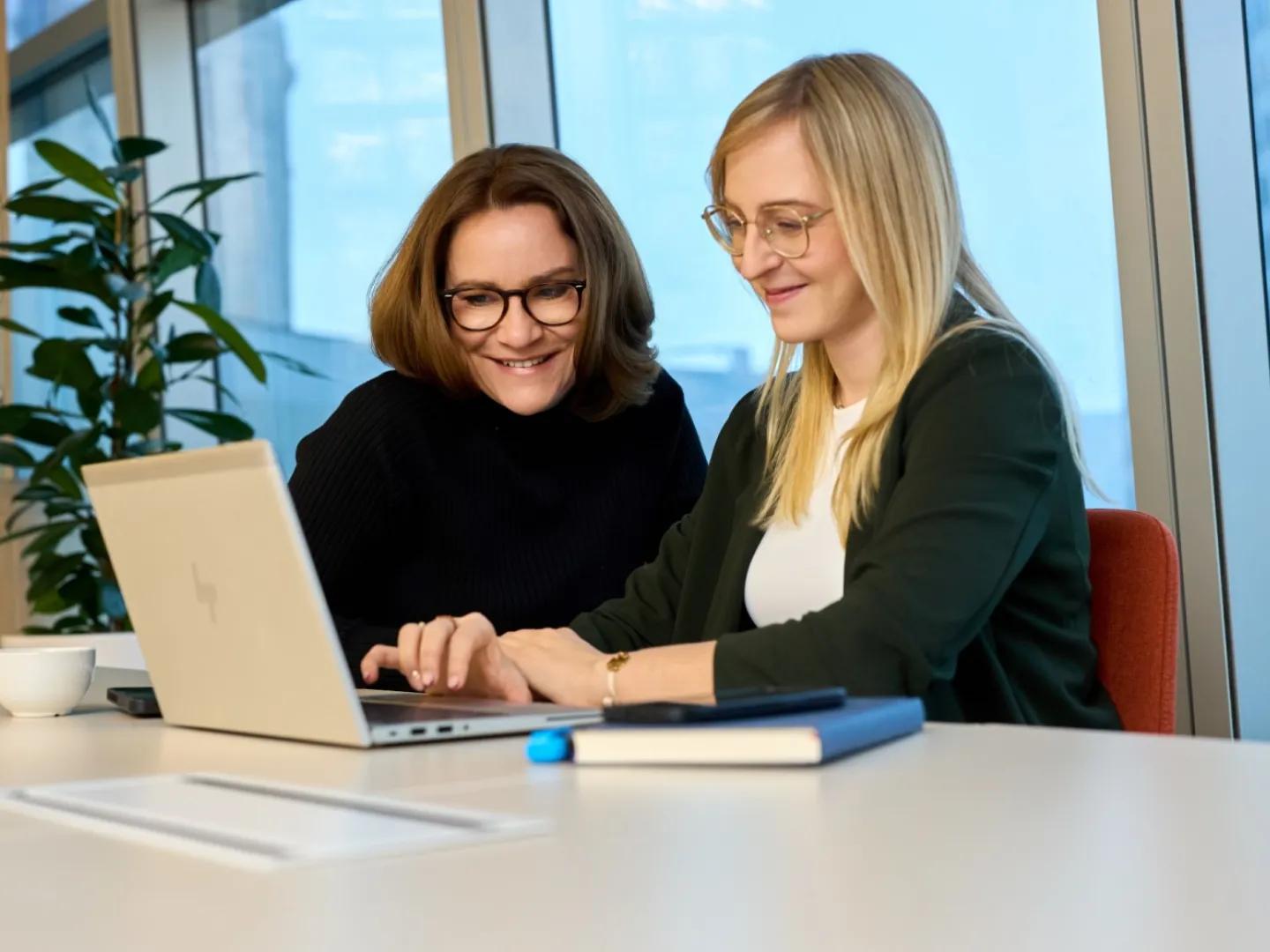 dwie kobiety przy komputerze rozmawiają