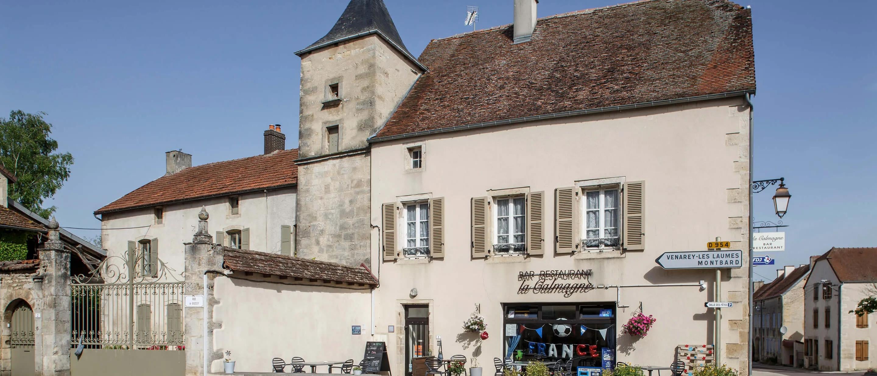Large stone building on quiet street corner in a French village 