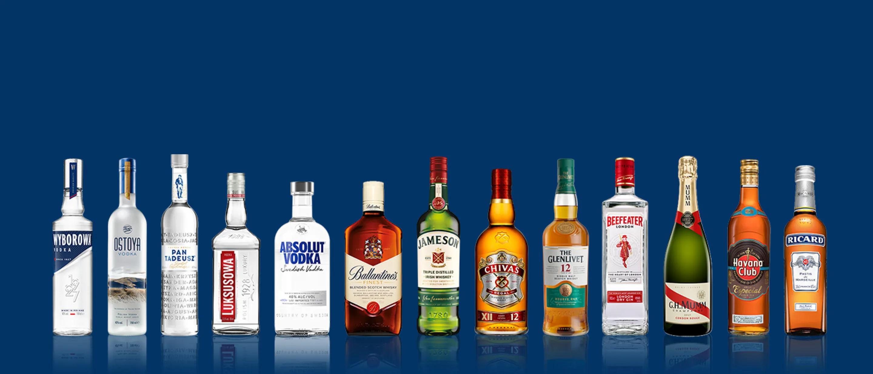butelki alkoholi marek Pernod Ricard na niebieskim tle