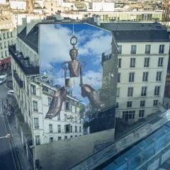 Mural on side of building with Parisian buildings surrounding